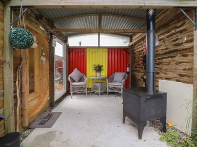 A snug area with seating and a stove at The Journeyman Luxury Shepherds Hut in Barnoldswick