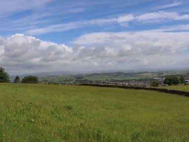 A landscape view with grass and hills at The Journeyman Luxury Shepherds Hut in Barnoldswick