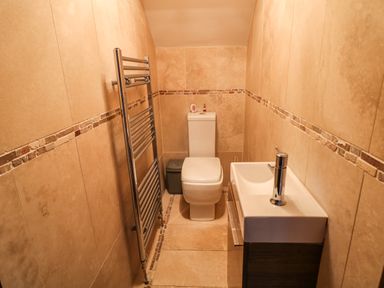 A small bathroom with a toilet sink and heated towel rail at The Upper Room in Ballymena