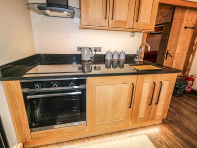 A kitchen counter with a stovetop oven kettle canisters and a sink at The Upper Room in Ballymena