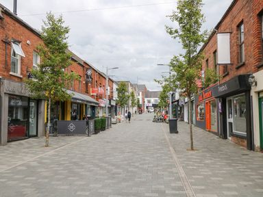 A pedestrian street with trees and shops on both sides at The Upper Room in Ballymena