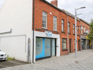 A street view of red brick buildings with a podiatry and chiropody clinic at The Upper Room in Ballymena