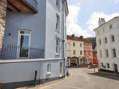 A street view with pastel coloured buildings and a shop at Ferryside in Kingswear