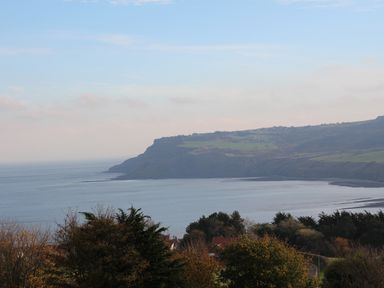 A coastal landscape showing a bay with cliffs and greenery at The Shepherd's Rest in Robin Hood's Bay