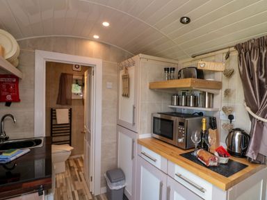 A kitchen area with countertop appliances and a bathroom visible through a doorway at The Shepherd's Rest in Robin Hood's Bay