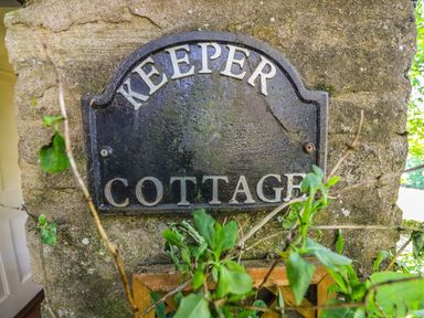 A sign reading Keeper Cottage on a stone wall with green leaves in front at Keepers in Nenthead near Alston