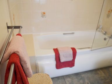 A bathroom with a bathtub and towels hanging on a rail and over the tub at Keepers in Nenthead near Alston