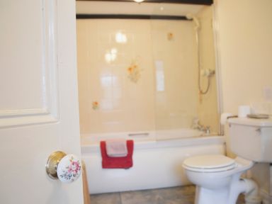 A bathroom with a bathtub towels and a toilet at Keepers in Nenthead near Alston