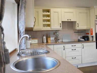 A kitchen with sink countertop cabinets and kitchen appliances at Bothy in Nenthall near Alston