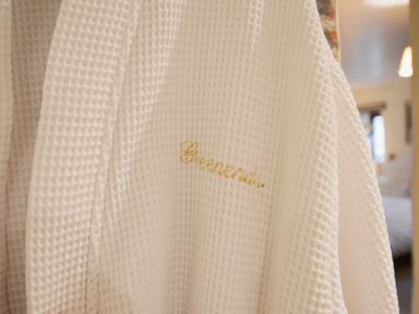 A close up of a white textured fabric with gold embroidered text in an indoor setting at Bothy Nenthall near Alston