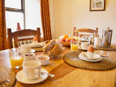 A breakfast table with boiled eggs toast jam fruit tea and orange juice at Chestnut in Nenthall near Alston