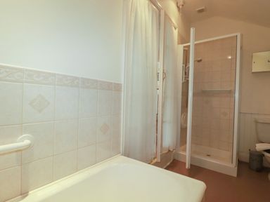 A bathroom featuring a bathtub, shower, and toilet at Vi’s Valley View, Pentewan