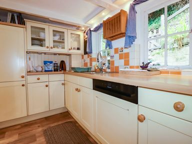 A kitchen with a sink and cupboards at Vi’s Valley View in Pentewan