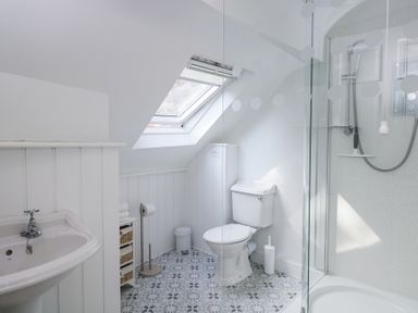 A bathroom with a toilet sink shower and skylight window at The Old School House in Lower Swell near Stow-On-The-Wold