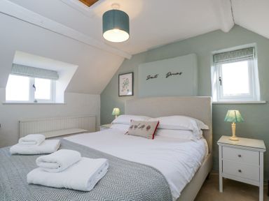 A bedroom with a bed and two bedside tables with lamps at The Old School House in Lower Swell near Stow-On-The-Wold