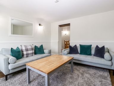A living room with two sofas a wooden coffee table and a wall mirror at Somerset House in Othery near Middlezoy