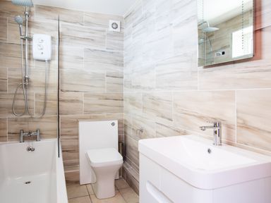 A bathroom with a bathtub shower toilet basin and mirror at Baywatch Sands in Polzeath