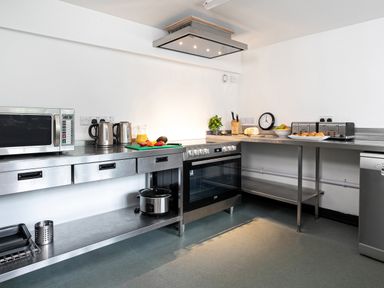 A kitchen with stainless steel counters microwave electric kettles stove and toaster at Thorney How in Grasmere
