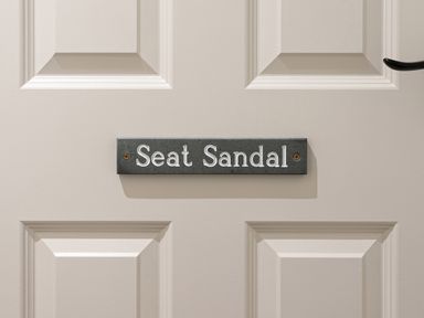 A door with a sign reading Seat Sandal at Thorney How in Grasmere