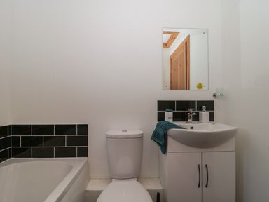 A bathroom with a toilet sink and bath at Bluebell Lodge Meadow view lodges in Brean