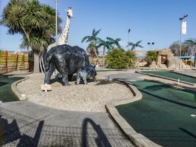 An outdoor mini golf course with artificial animal sculptures including a giraffe and two hippos at Bluebell Lodge Meadow view lodges in Brean