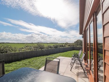 An outdoor seating area with a table and chairs at Delphine Lodge, Meadow View Lodges Brean