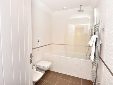 A bathroom with a bathtub shower toilet and heated towel rail at Skylarks in Ferintosh near to Dingwall