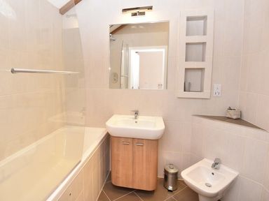 A bathroom with a bathtub sink bidet mirror and built in wall shelves at Skylarks Ferintosh near to Dingwall