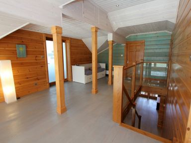 A wooden hallway with a white couch and stairs at Eagle Lodge in Uig near Stornoway
