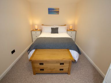 A bedroom with a double bed and two bedside tables with lamps at Braemore Chalet Tarbert Isle Of Harris