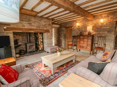 A living room with a wood-burning stove a coffee table and sofas at Pen Bont Home Farm Upper Chapel near Builth Wells
