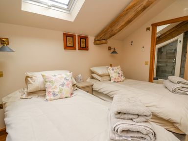 A bedroom with two single beds towels on a bed and wooden beams at Pen Bont Home Farm Upper Chapel near Builth Wells