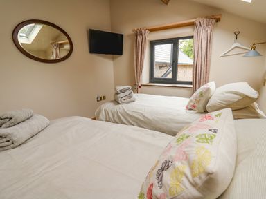 A bedroom with two single beds with folded towels pillows and a window at Pen Bont Home Farm Upper Chapel near Builth Wells