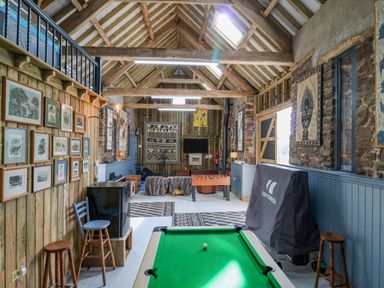 A game room with a pool table foosball table chairs framed pictures and exposed beam ceiling at Pen Bont Home Farm in Upper Chapel near Builth Wells