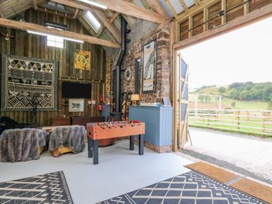 A recreational room with a foosball table two chairs with fur covers and wall decorations at Pen Bont Home Farm in Upper Chapel near Builth Wells