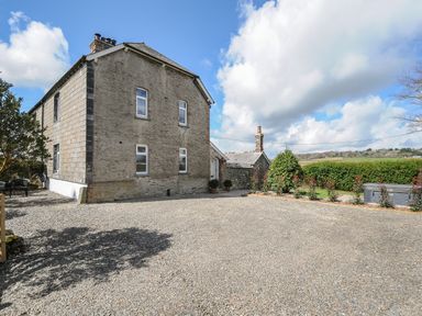 A large stone house with gravel driveway and garden area at Skylarks in No Mans Land near Looe