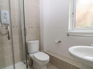 A bathroom with a toilet a shower with glass door a sink and a window at No 51 Valley Lodges Honicombe Manor near Gunnislake