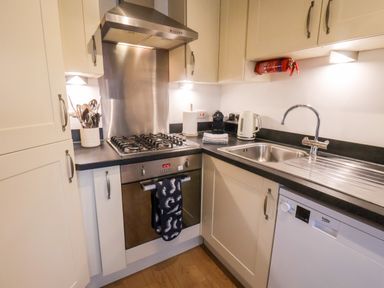 A kitchen with a stove oven sink kettle utensils and dishwasher at Stoker's Rest in Whitby