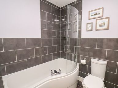 A bathroom with a bathtub shower combination and a toilet at Stoker's Rest in Whitby