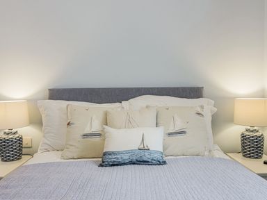 A bed with multiple pillows and two bedside lamps at Apartment 18 Burgh Island Causeway in Bigbury-On-Sea