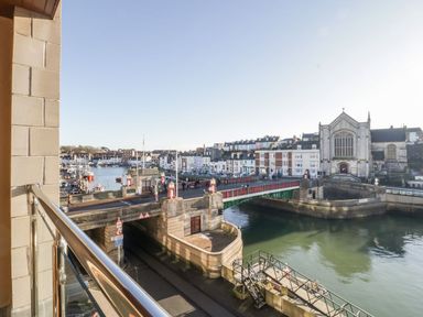 A view of a bridge over a river with buildings and boats in the background at Townbridge Apartment in Weymouth
