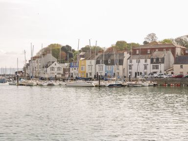 A harbor with sailboats docked and houses along the waterfront at Townbridge Apartment in Weymouth