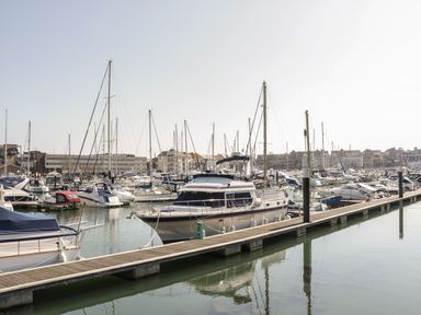 A marina with multiple yachts and sailboats docked alongside piers at Townbridge Apartment in Weymouth