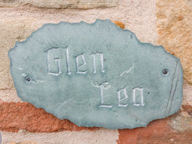A carved stone plaque with the text Glen Lea attached to a brick wall at Glen Lea Giggleswick Settle