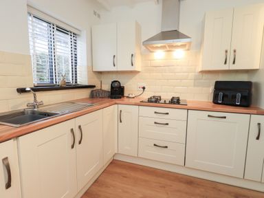 A kitchen with a sink and gas stove at Glen Lea, Giggleswick, Settle