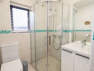 A bathroom with a shower, sink, and toilet at Glen Lea in Giggleswick, Settle