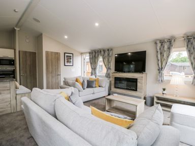 A living room with sofas a television and fireplace at Parkers Place in Carnforth