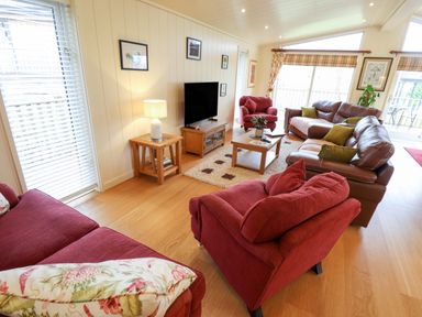 A living room with sofas chairs a television and coffee table at Tanqueray Lodge Kenwick near Louth