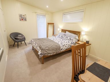 A bedroom with a bed a desk a chair and a standing mirror at Tanqueray Lodge in Kenwick near Louth