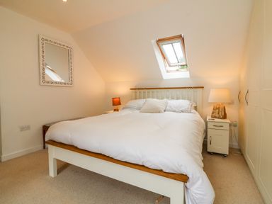 A bedroom with a bed under a skylight window and bedside tables with lamps at Barleside in Dulverton
